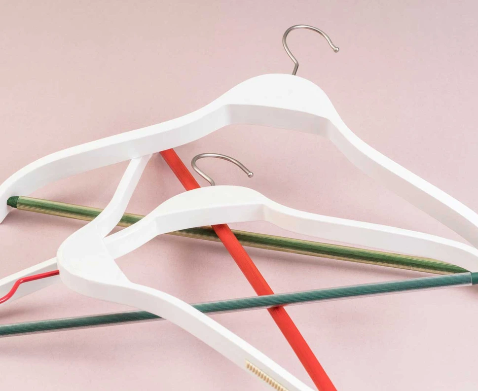 Brand shoot frame: pink hangers on a soft pale ground, a clean editorial composition for the Basi Group campaign.